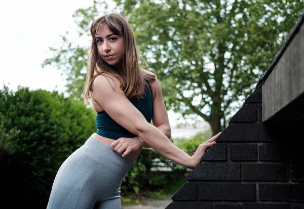 Mulher Fitness Jovem Posando Enquanto Estende Contra Telhado Inclinado Ela — Fotografia de Stock