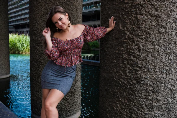 Çekici bir kadının doğal portresi. Bir sütuna yaslanıyor..