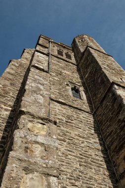 Taş kilise kulesi antik Avrupa mimarisi ve yapısını gözler önüne seriyor, açık mavi gökyüzüne karşı dimdik ayakta duruyor, tarihi, mirası ve dini inancı çağrıştırıyor.