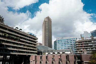 Barbika malikanesinin bir kısmını oluşturan acımasız beton binalar, belirgin balkonlar ve bulutlu bir gökyüzüne karşı çeşitli modern ve geleneksel mimari tarzlar içeriyor.