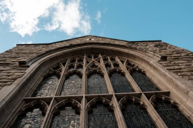 Süslü, gotik bir penceresi, karmaşık bir izi ve mavi gökyüzüne uzanan boyalı camları olan antik taş kilise, miras ve inancı çağrıştırıyor.