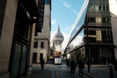 St Paul 'un katedral kubbesi, Londra' nın hareketli caddesinde modern cam ofislerin üzerine yükseliyor ve tarihi mimariyle çağdaş şehir yaşamı arasındaki çarpıcı zıtlığı vurguluyor.