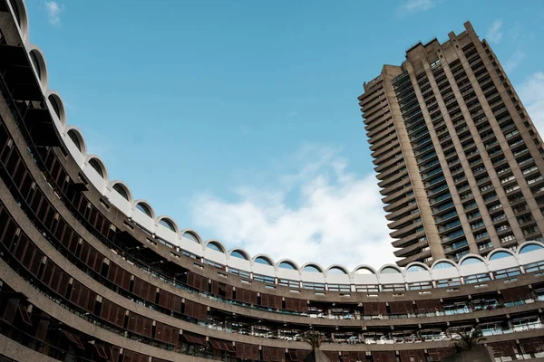 Barbika malikanesinin belirgin kıvrımlı beton binaları ve yükselen yerleşim blokları Londra 'nın mavi gökyüzüne karşı ikonik vahşi mimarisini tanımlıyor