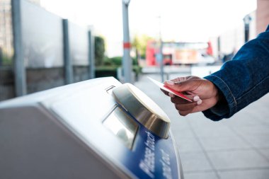 Bir toplu taşıma terminalinde erişimi olmayan bir kredi kartı kullanan turist, kentsel ulaşım sisteminde zahmetsizce gezinirken modern seyahat teknolojisinin kolaylığını deneyimliyor