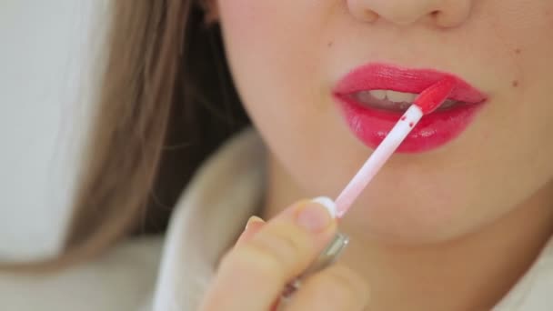 La joven hermosa chica pinta los labios con lápiz labial rojo — Vídeos de Stock