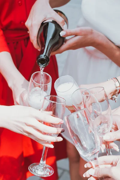 Schöne junge Mädchen in roten Kleidern feiern Junggesellenabschied und trinken Champagner — Stockfoto