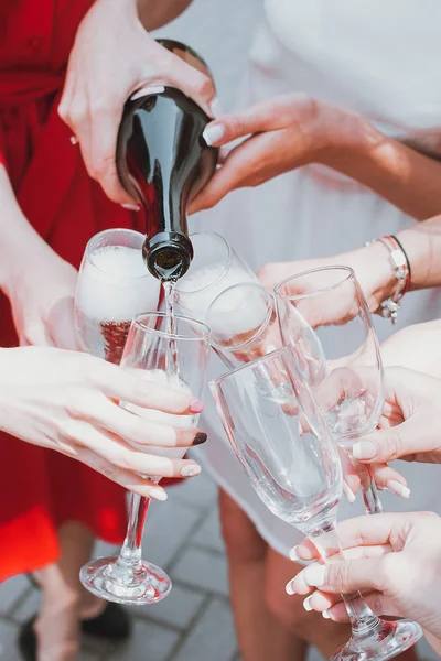 Hermosas chicas jóvenes en vestidos rojos están celebrando una despedida de soltera y beber champán —  Fotos de Stock