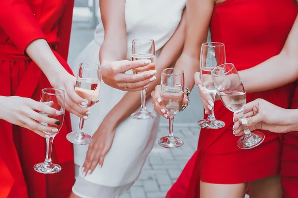 Meninas bonitas em vestidos vermelhos estão comemorando uma festa de despedida de solteira e beber champanhe — Fotografia de Stock