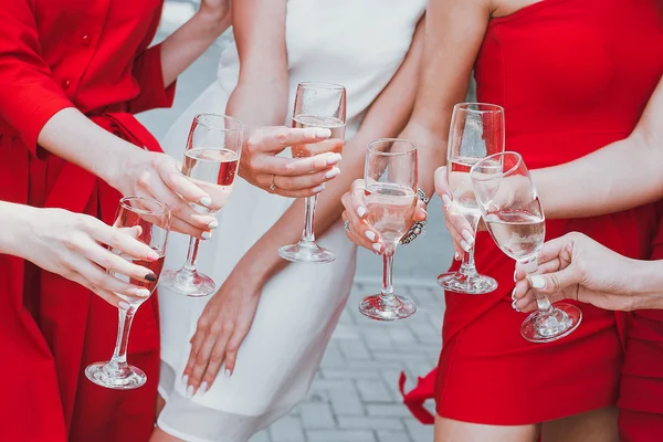 Meninas bonitas em vestidos vermelhos estão comemorando uma festa de despedida de solteira e beber champanhe — Fotografia de Stock