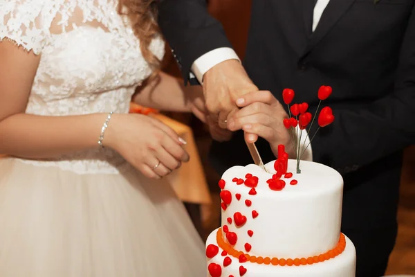 La pareja en la boda corte hermoso pastel — Foto de Stock