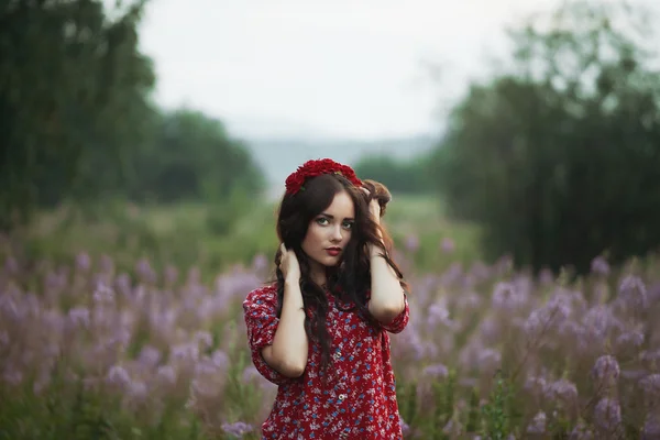 Hermosa joven en un campo en los colores de fondo — Foto de Stock