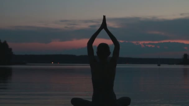 Ragazza fa yoga al tramonto sulla cima di una montagna — Video Stock