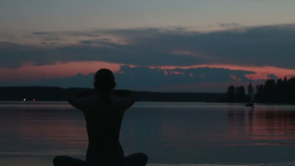 Flicka gör yoga i solnedgången på toppen av ett berg — Stockvideo