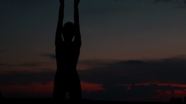 Meisje doet yoga bij zonsondergang op de top van een berg — Stockvideo