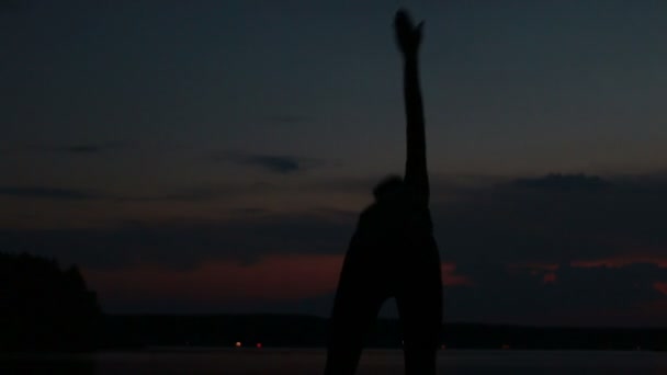 Mädchen macht Yoga bei Sonnenuntergang auf einem Berg — Stockvideo