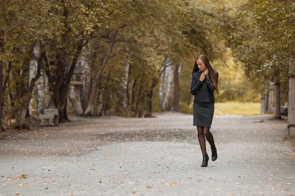 Chica joven caminando en el parque de otoño — Foto de Stock