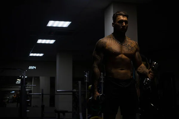 Atleta Masculino Musculoso Con Torso Desnudo Tatuado Parado Gimnasio Oscuro —  Fotos de Stock