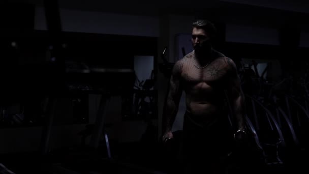Ισχυρός αρσενικό bodybuilder κάνει ασκήσεις με αλτήρες — Αρχείο Βίντεο