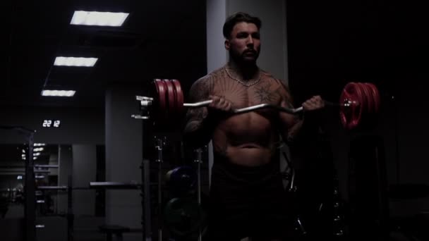 Ισχυρός αρσενικό bodybuilder κάνει ασκήσεις με αλτήρες — Αρχείο Βίντεο