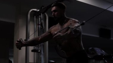 Güçlü erkek vücut geliştirici halterlerle egzersiz yapıyor.