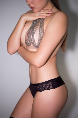 Ekin çekici, zayıf, gözleri kapalı, karanlık odada poz veren çıplak kadın.