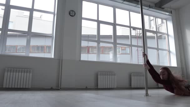 Seductive female doing pole dance in studio — Stock Video