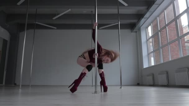 Förförisk kvinna gör pole dance i studio — Stockvideo