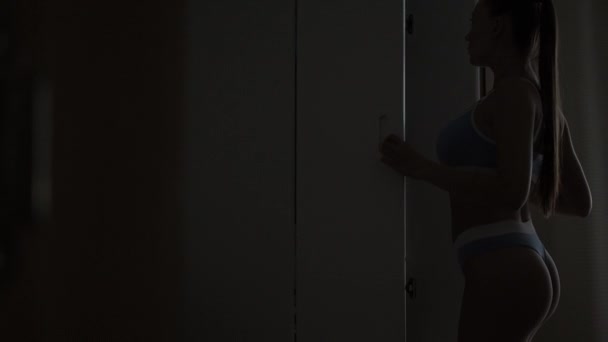 Девушка вынимает одежду из шкафа — стоковое видео