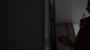 Kız dolaptan giysileri çıkarıyor.