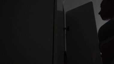 Kız dolaptan giysileri çıkarıyor.