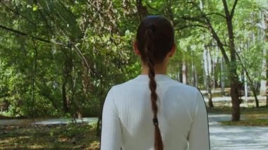 Trendi seven bir kadın parkta duruyor.