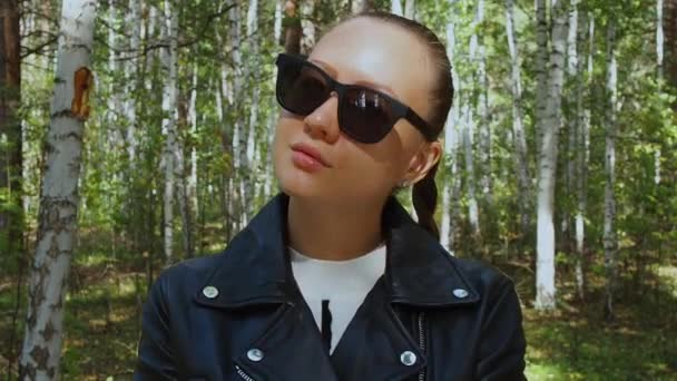 Стильна жінка знімає куртку в парку — стокове відео