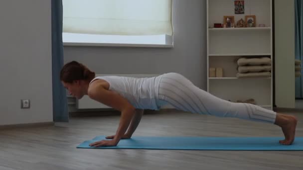Młoda kobieta praktykująca jogę w studio — Wideo stockowe