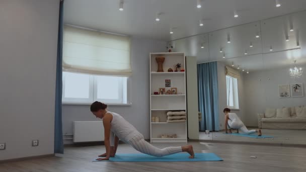 Mujer joven practicando yoga en estudio — Vídeos de Stock