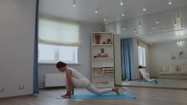 Mujer joven practicando yoga en estudio — Vídeos de Stock