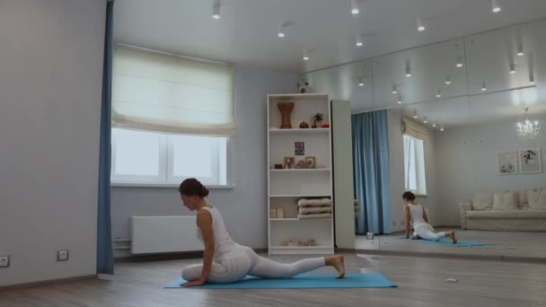 Mujer joven practicando yoga en estudio — Vídeos de Stock