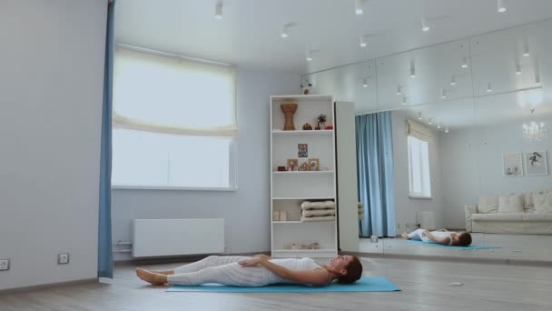 Ung kvinna utövar yoga i studio — Stockvideo