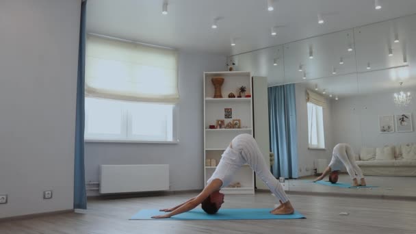 Junge Frau praktiziert Yoga im Studio — Stockvideo