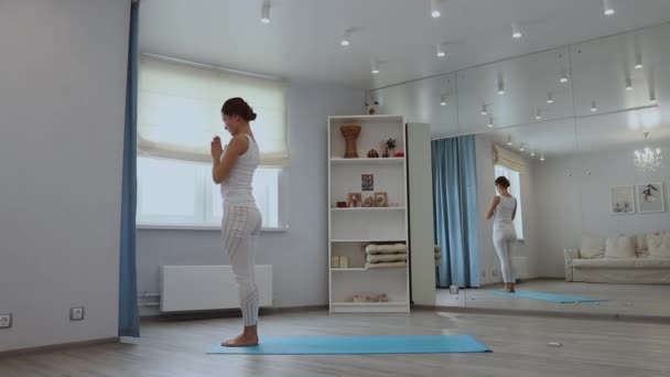 Mujer joven practicando yoga en estudio — Vídeos de Stock