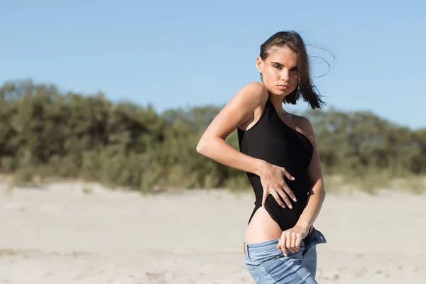 Slim Kobieta Modnym Body Dżinsy Dotykając Ciała Podczas Odpoczynku Plaży — Zdjęcie stockowe