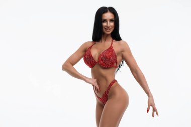 Kırmızı bikinili güzel gülüşlü ince bir kadın beyaz arka planda izole edilmiş belden el ele tutuşuyor.