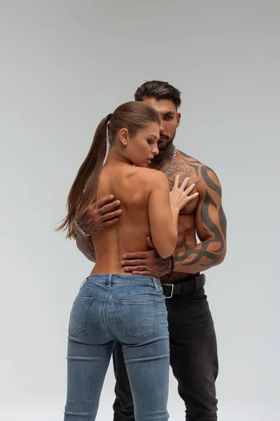 Привлекательная Женщина Обнимает Красивого Мужчину Рубашки Татуировками Сзади Смотрит Камеру — стоковое фото