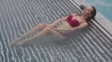 Havuzda dinlenen baştan çıkarıcı bir kadın.