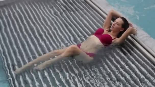 Uwodzicielska kobieta odpoczywająca w basenie — Wideo stockowe