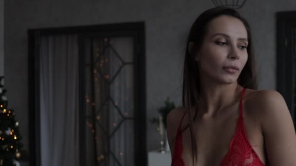 Fastuos model de femeie tânără purtând diferite lenjerie intimă elegantă în timpul sărbătorilor de Crăciun acasă — Videoclip de stoc