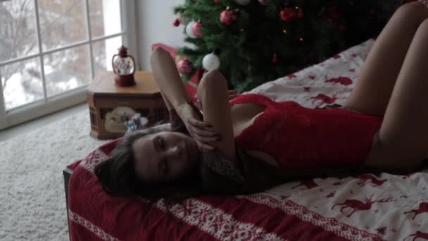 Sensual young woman resting at home in different underwear during Christmas holidays — Stock Video