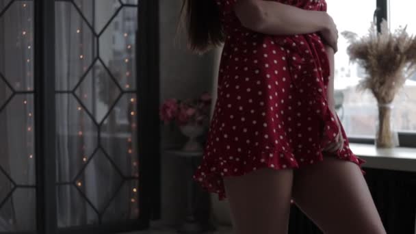 Seksi elbiseli şık genç bir kadın, el ele tutuşup duruyor. — Stok video