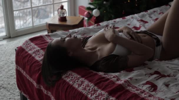 Sensual joven mujer descansando en casa en ropa interior diferente durante las vacaciones de Navidad — Vídeos de Stock