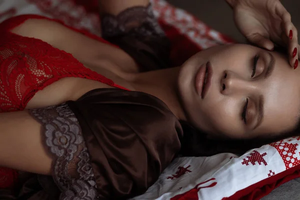 Uzun Siyah Saçlı Zarif Kırmızı Sütyenli Rahat Bir Yatakta Uzanan — Stok fotoğraf