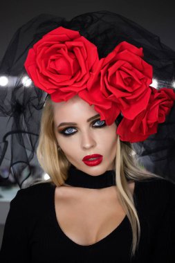 Parlak makyajlı çekici gotik kadın harika bir başlık takıyor ve kameraya bakıyor.